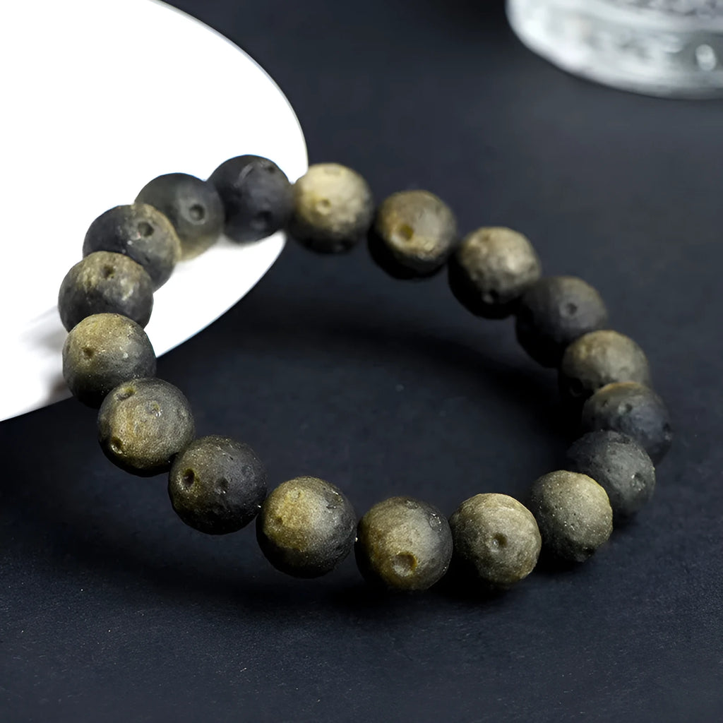 Natural obsidian crater ball bracelet with textured beads in silver stone meteorite finish.