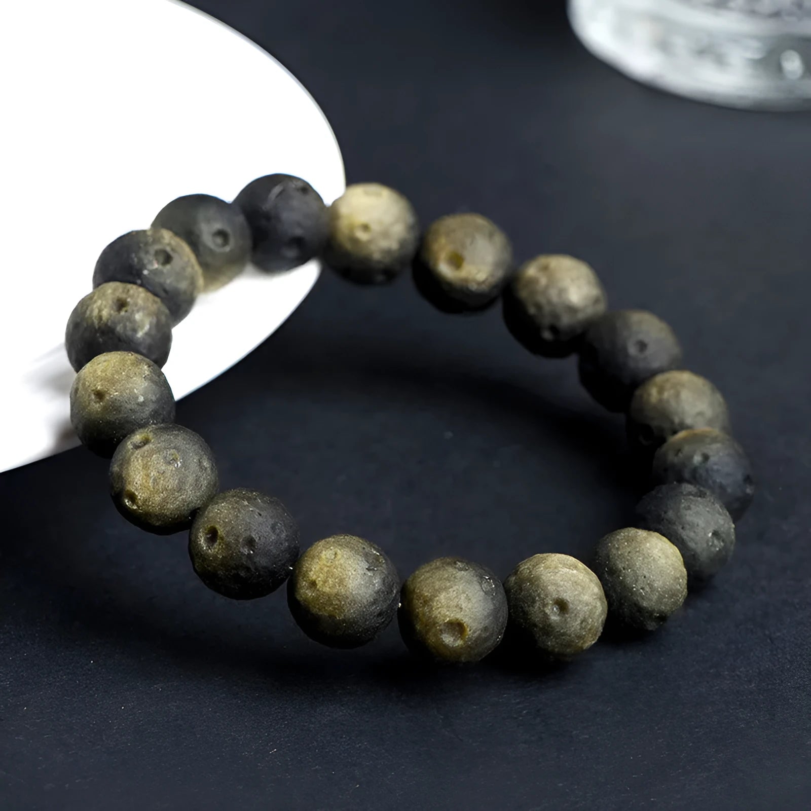 Natural obsidian crater ball bracelet with textured beads in silver stone meteorite finish.