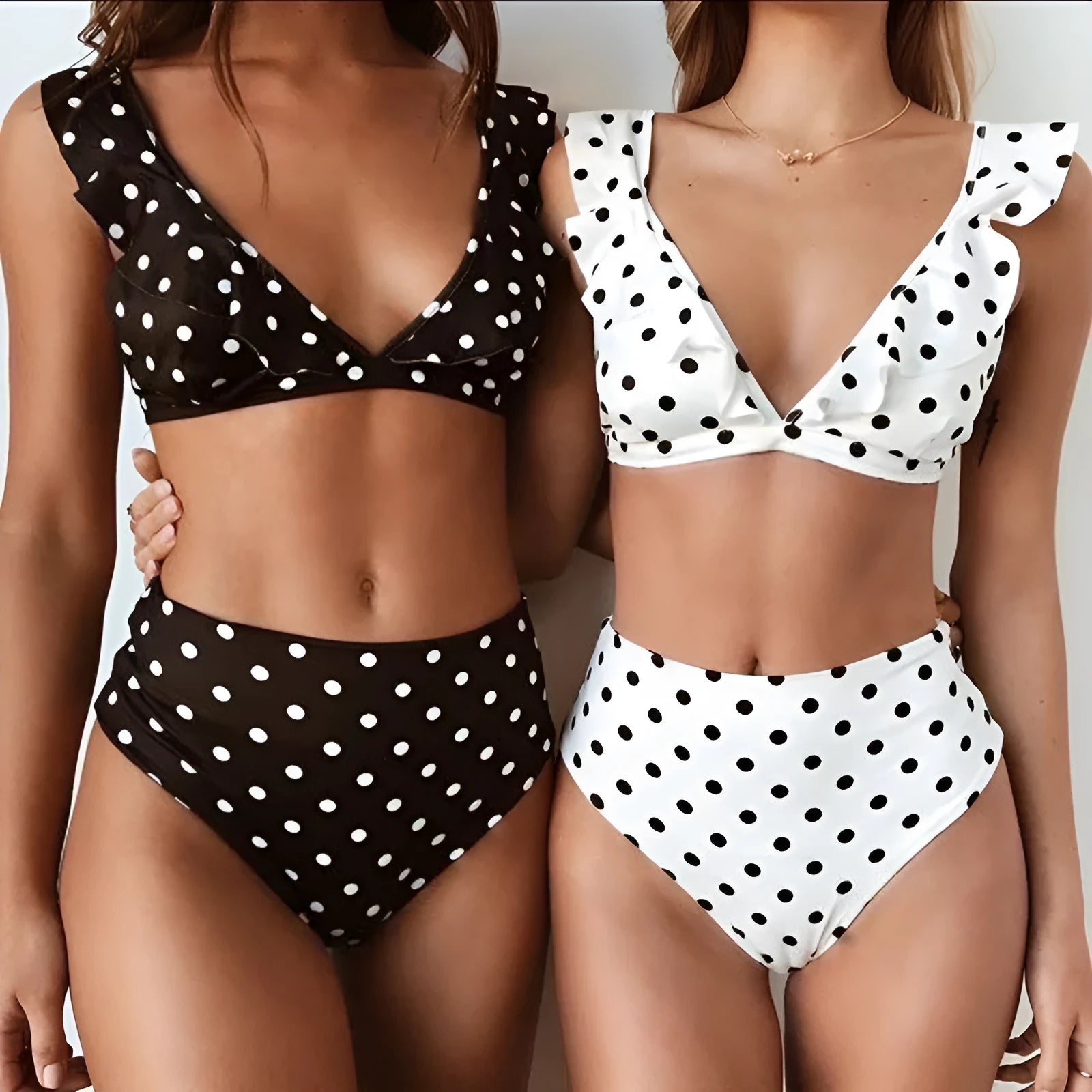 Women's black and white polka dot bikini set with ruffled deep V-neck top and matching shorts.