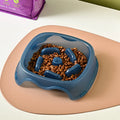 Blue plastic dog slow feeder bowl with internal maze pattern for portion control.