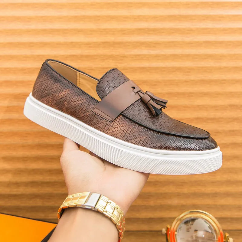 Men's black casual leather shoes with fringe detail on round toe, showing low heel profile.