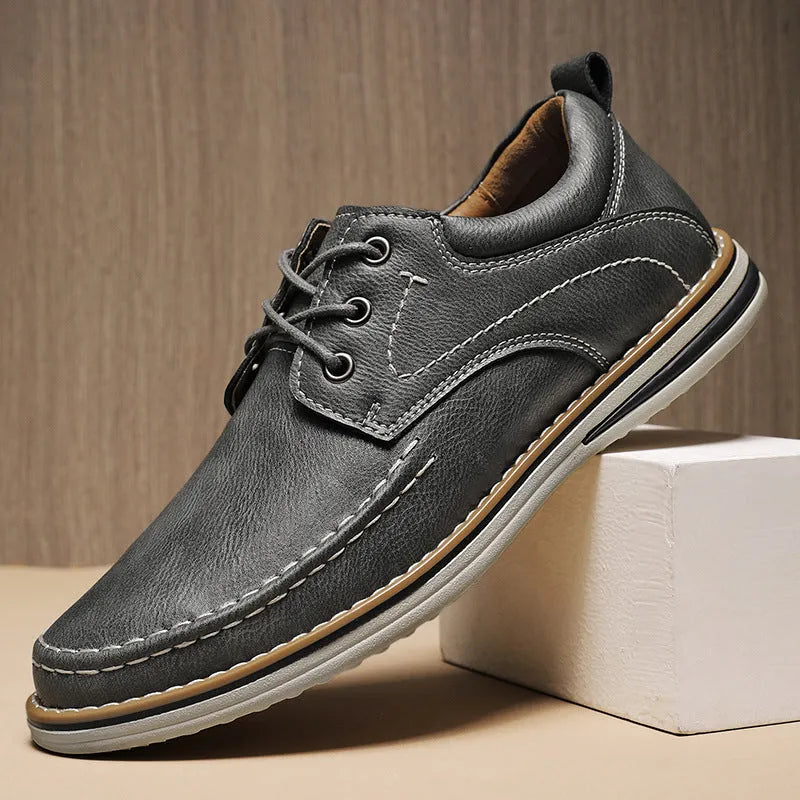 Men's black genuine leather lace-up casual shoes with round toe and low rubber sole on a white background.