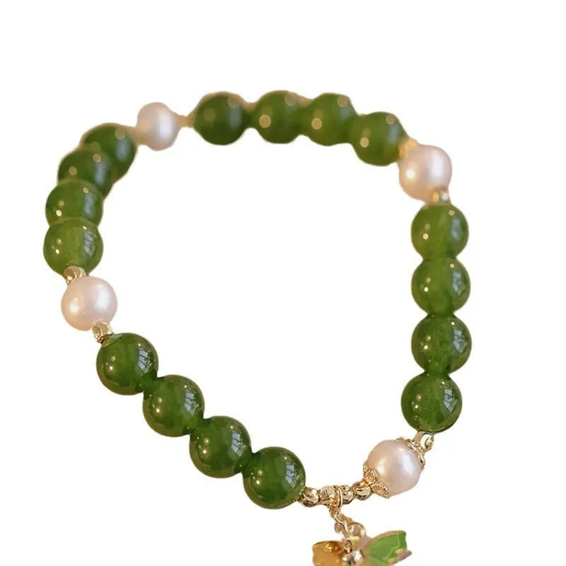 Close-up of a round natural green chalcedony bracelet on a woman's wrist.
