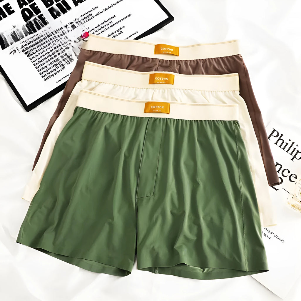 Pack of three pairs of men's solid colour loose fit ice silk nylon underwear on a white background.