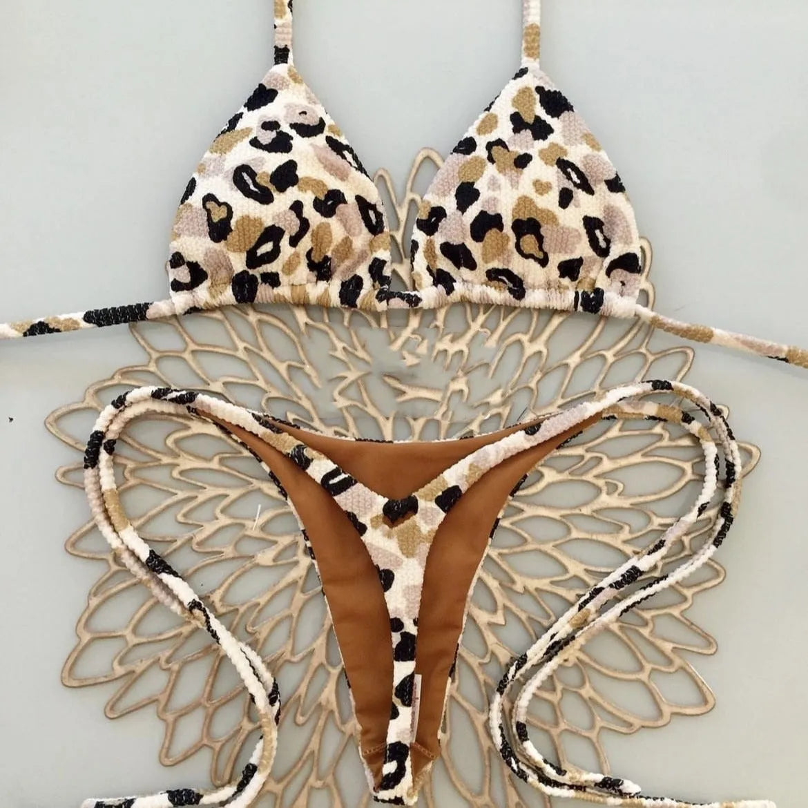 Women's printed bikini swimsuit on a hanger, showing briefs style with quick-drying fabric and cotton lining.
