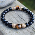 Tigereye cut obsidian bracelet with 8mm black beads on neutral background