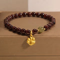 Women's crystal bracelet with a cat's paw garnet motif on a wrist.