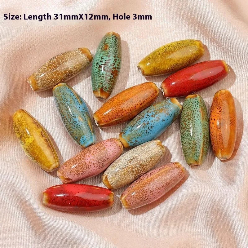 Ceramic bullet beads for jewellery making in various glaze colours including pink, yellow, blue, and red