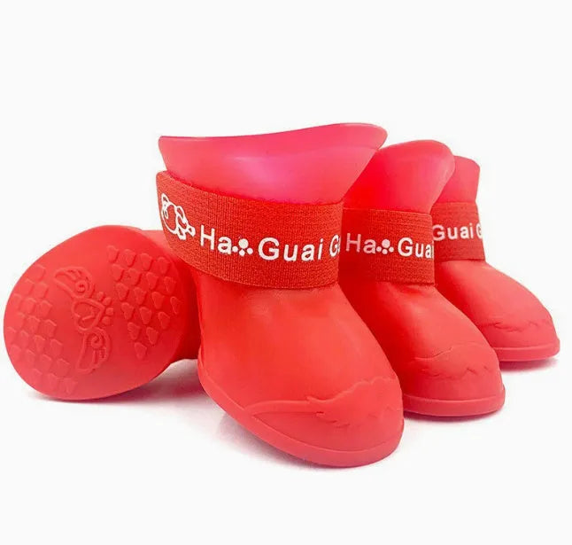 Four rubber pet rain shoes in various colours with anti-slip soles for dog paw protection