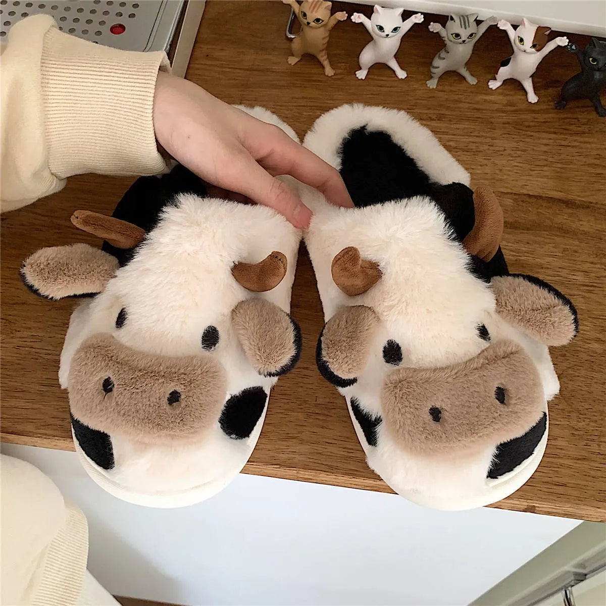 White and coffee cartoon cow slippers for women with plush faux fur and a textured non-slip sole.