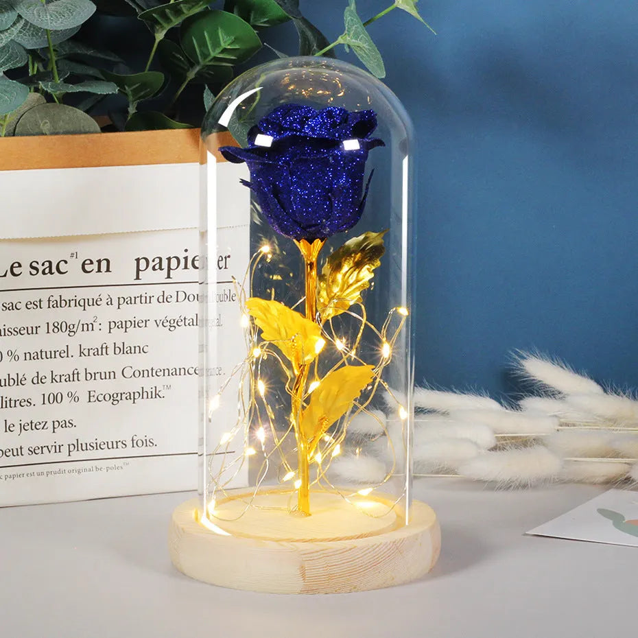 Glass dome covering a red eternal rose with coiled battery-powered LED lights on bendable copper wire.