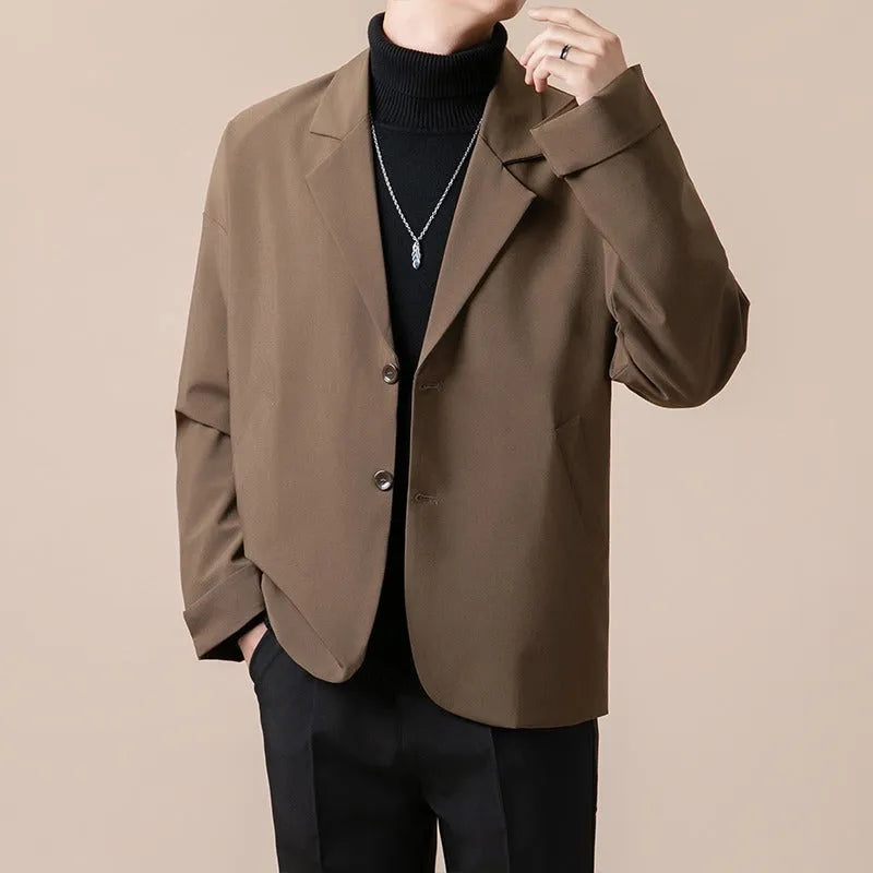 Man wearing a loose-fit apricot coloured casual suit jacket in a light business style.