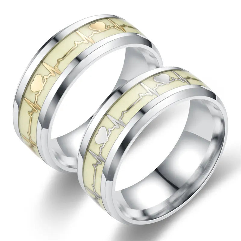 Gold heart-shaped stainless steel lovers ring with luminous glow, on white background