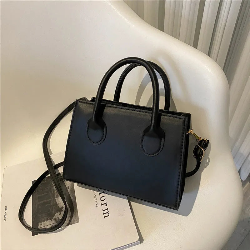 Small square shoulder bag in PU leather with single strap and document pocket, shown in available colours