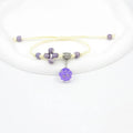 Close-up of a hand-woven glass bracelet with large 1.4cm beads containing real dried flowers in various colours.