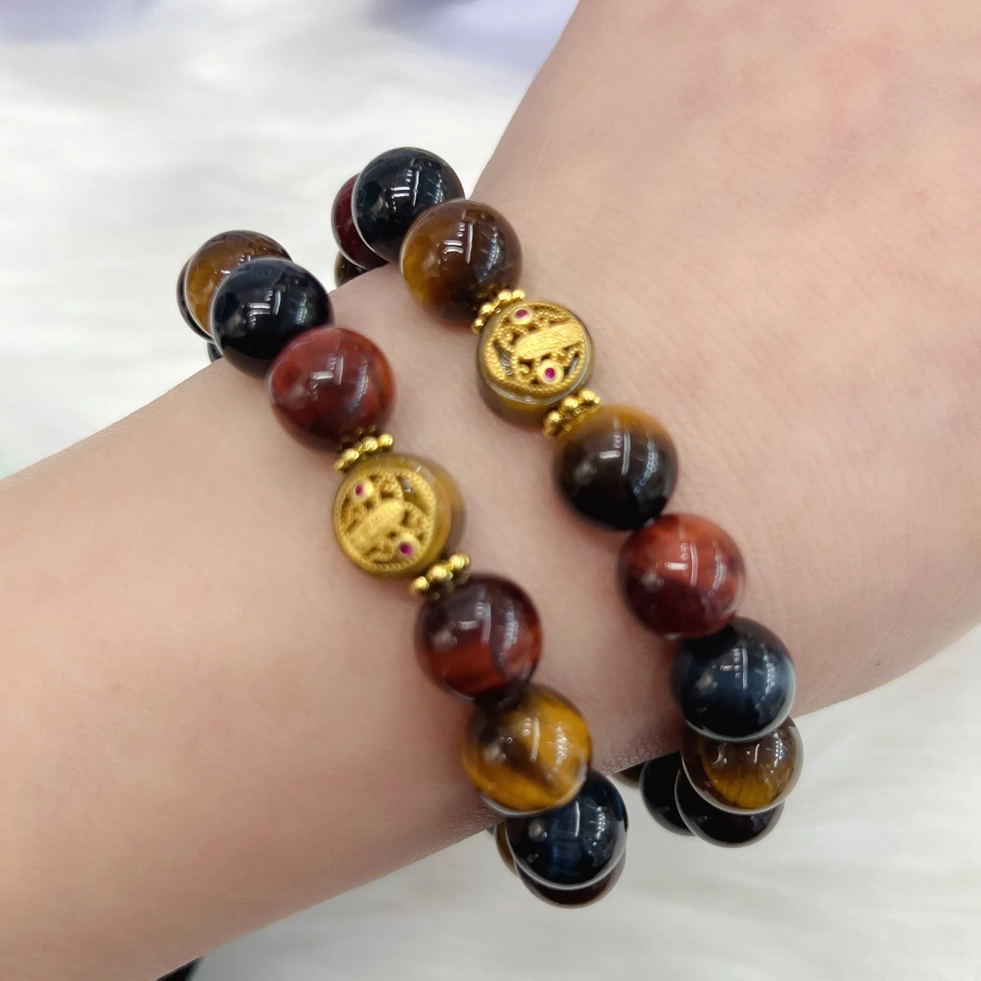 Natural golden-brown tiger eye gemstone bead bracelet with an adjustable clasp on a wrist.