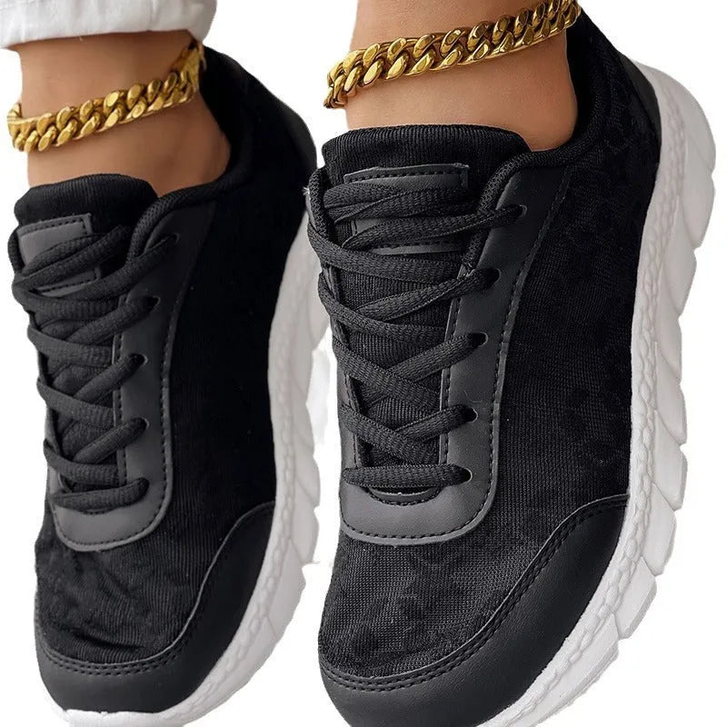 Women's white canvas running shoe with flat heel and round toe on a plain background