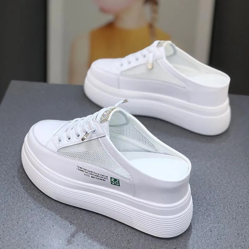 White women's platform trainers with mesh panels and a round toe on a rubber sole.