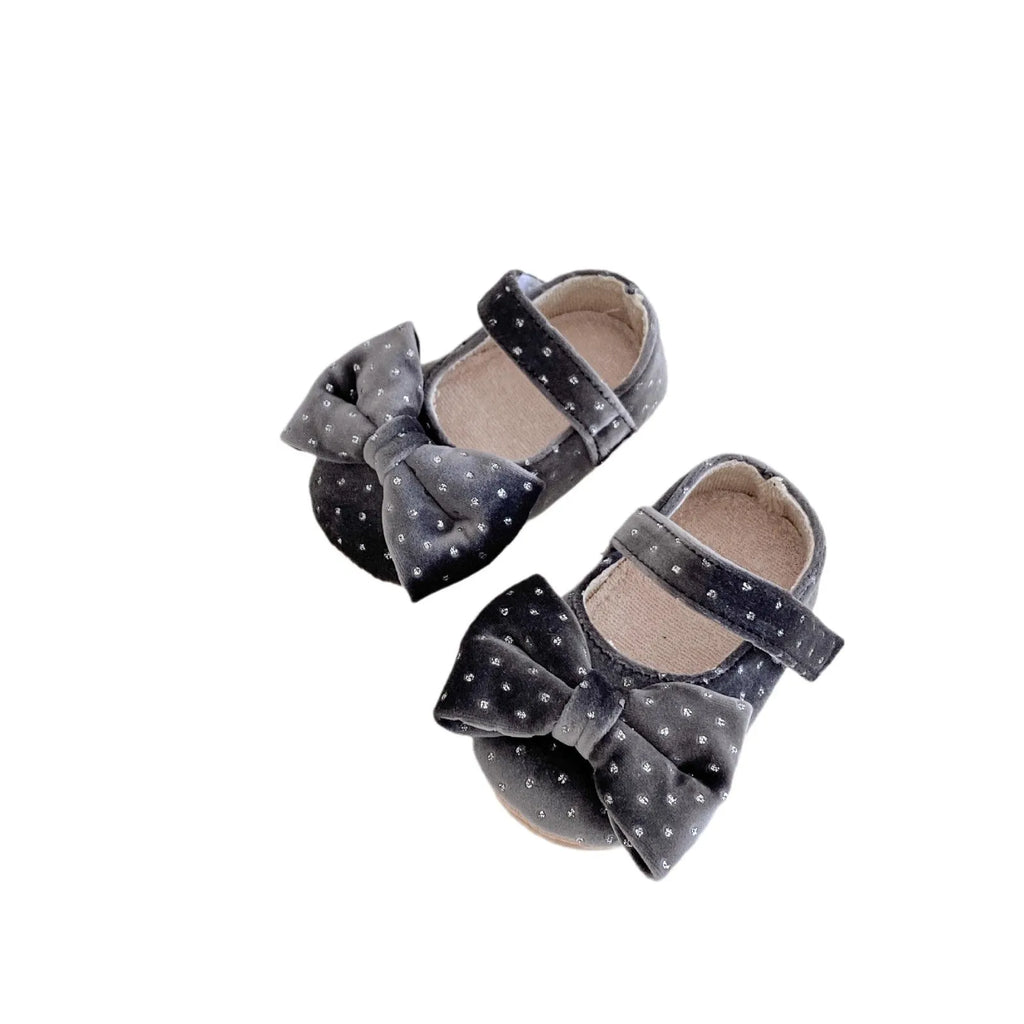 Baby girl toddler shoes with big bow and dots pattern in black on white background