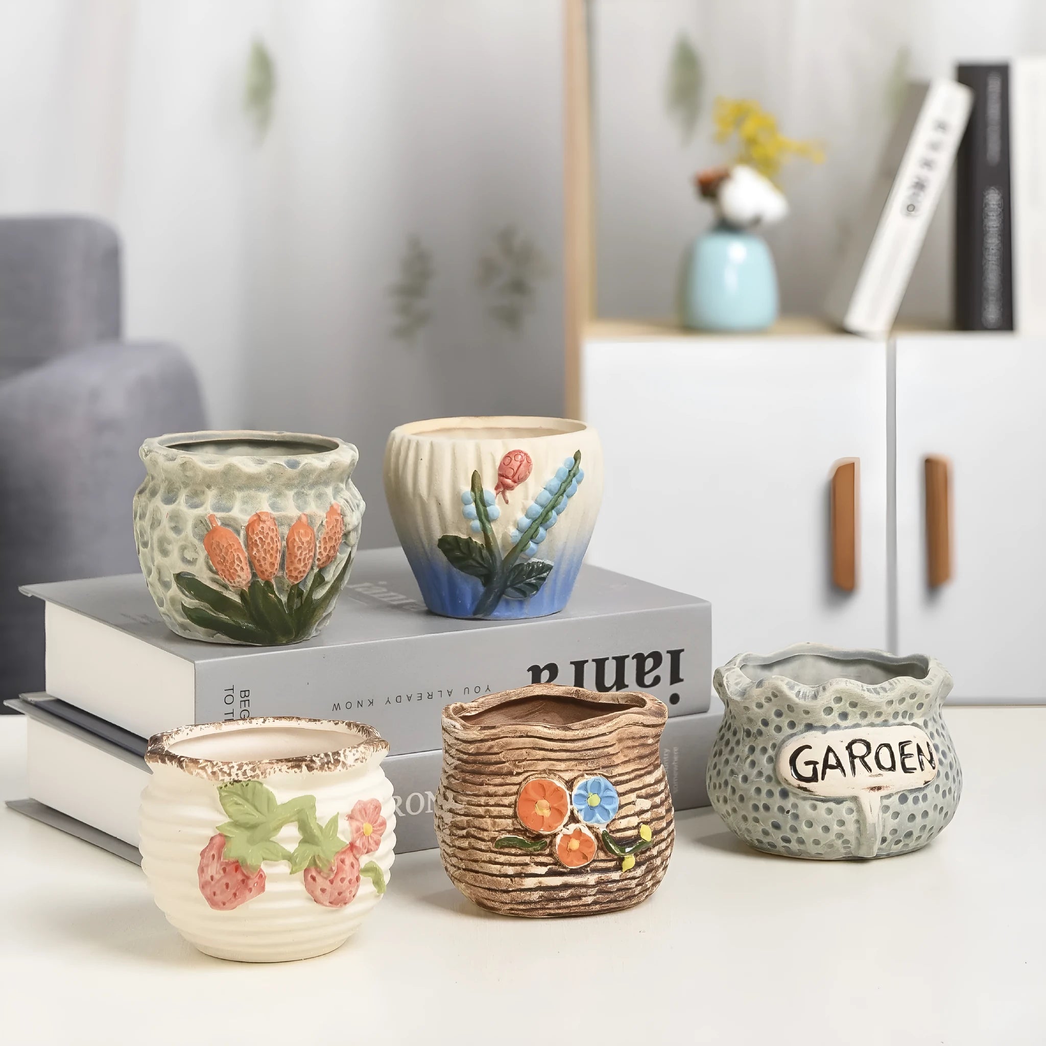 Three breathable stoneware succulent flower pots in hand-painted glaze colours on a tabletop with small succulents inside