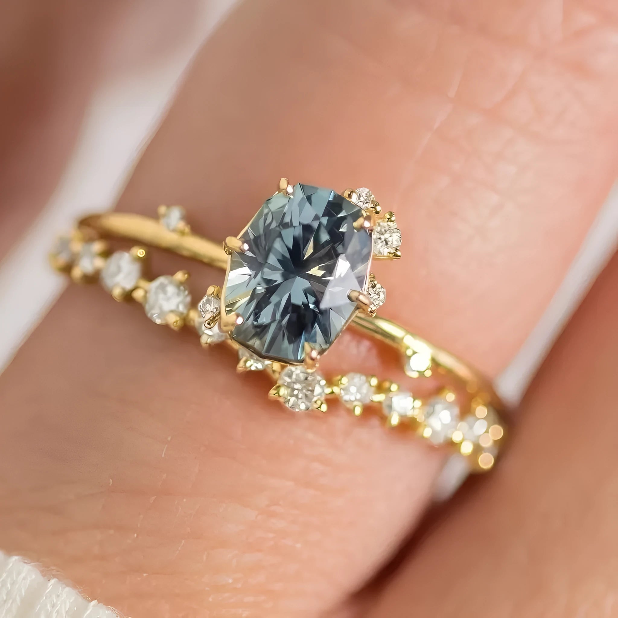 Close-up of a gold-plated floral ring with a central green zircon stone on a model's hand.