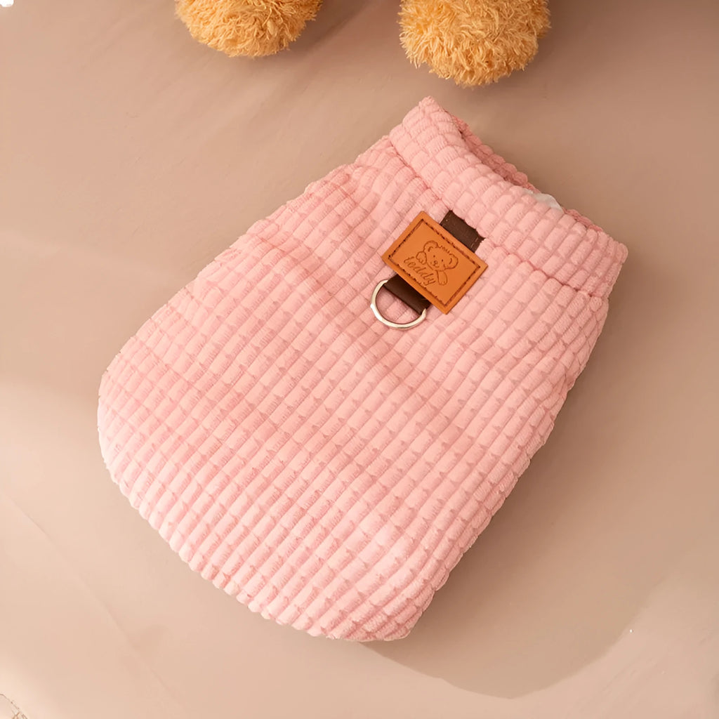 Pink ribbed corduroy dog vest with metal leash ring and bear emblem tag, sizes XS to XXL.