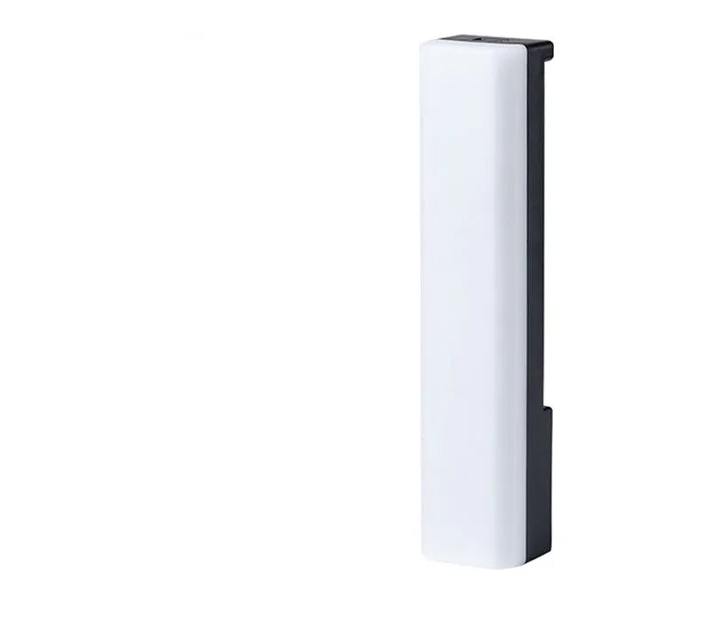 Slender black 3D RGB ambiance lamp with colourful LEDs on a desktop next to a PC monitor.