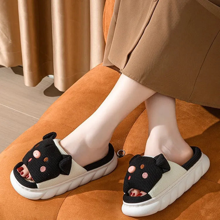 White linen open toe flip flop slippers for couples on a light background, showing PVC sole and strap detail.