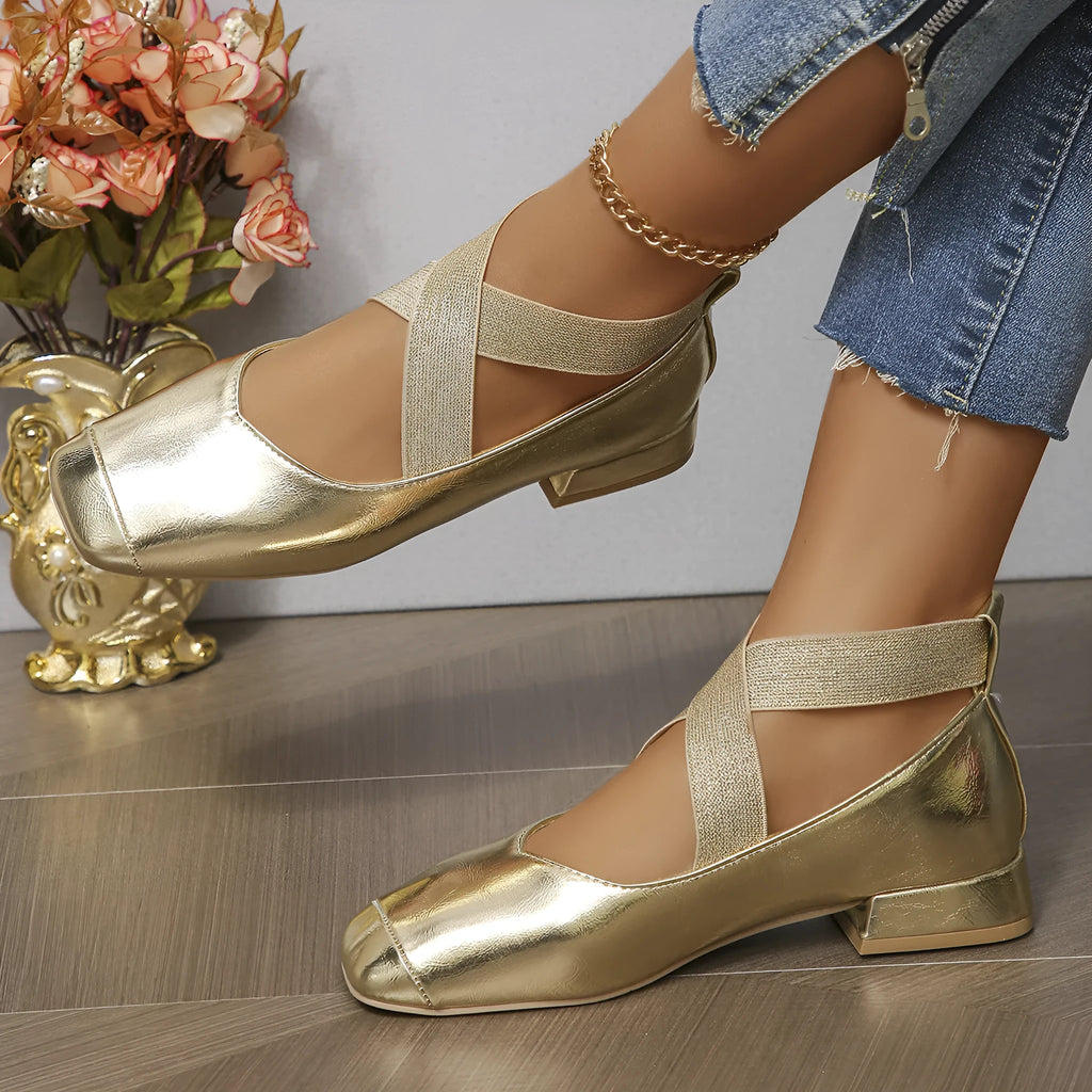 Gold French style slip-on evening pumps with square toe and low heel on a white background