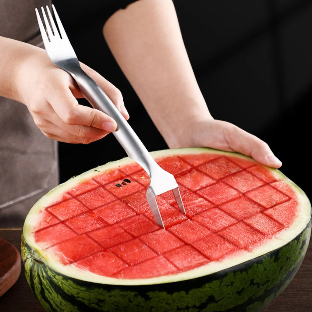 Silver stainless steel watermelon slicer with a 26cm handle and a 3.6cm wide rounded fork head.