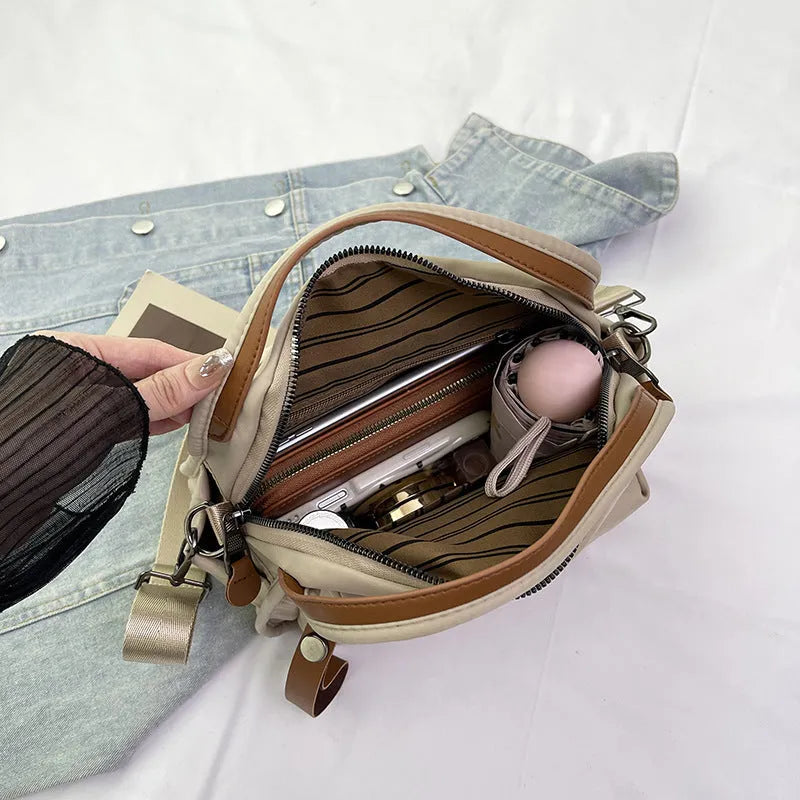 Nylon shoulder bag 25x11x23cm pillow shape with zippered compartment and outer pocket, available in brown, khaki, black, beige