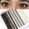 False eyelash kit with natural segmented clusters, adhesive tubes, tweezers and brushes on pink background