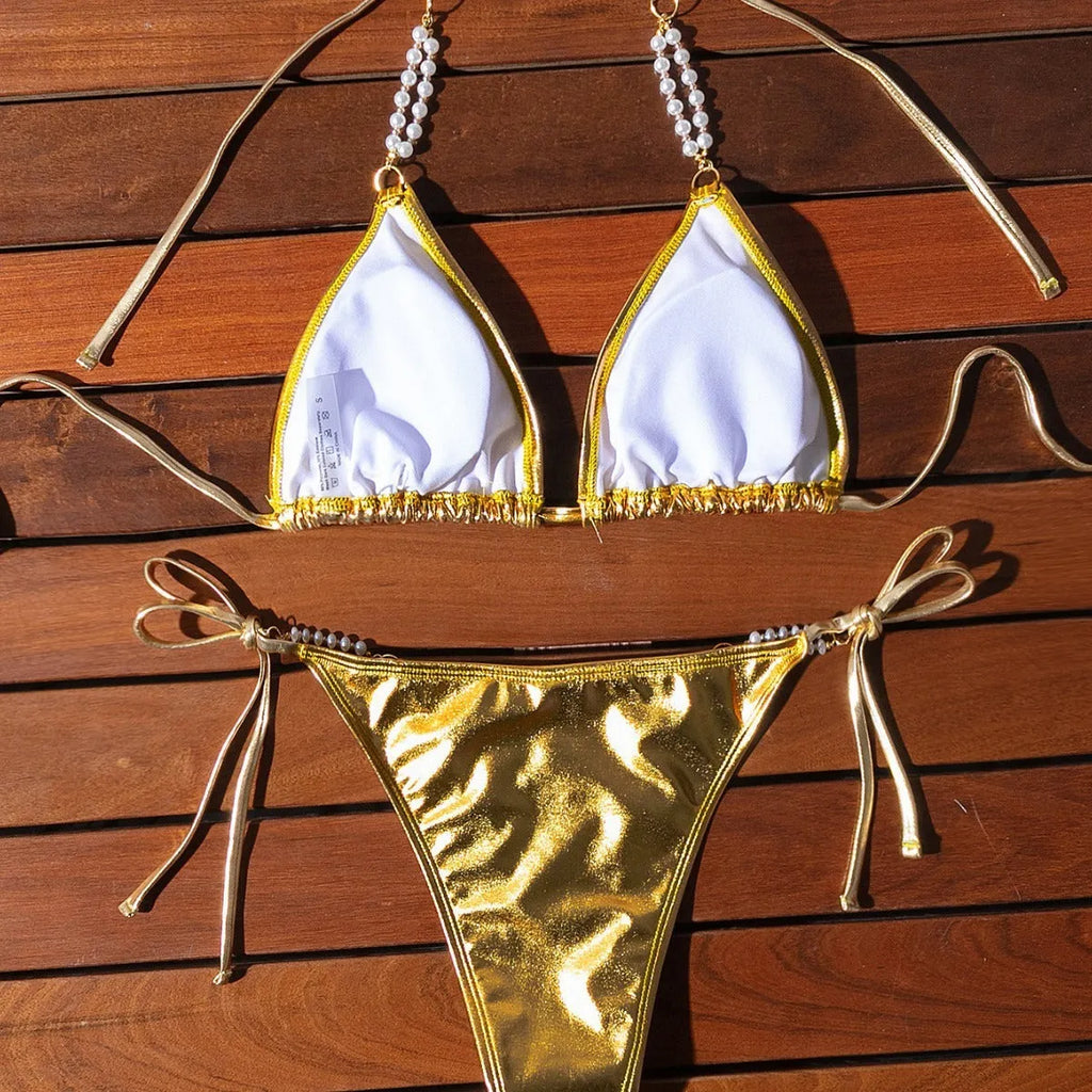 Gold halter neck bikini top with lace-up front and pearl chain, paired with brief-style bottoms