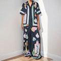 Black women's casual two-piece set with cartoon print, featuring cardigan and matching pants.