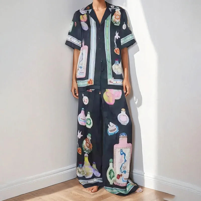 Black women's casual two-piece set with cartoon print, featuring cardigan and matching pants.
