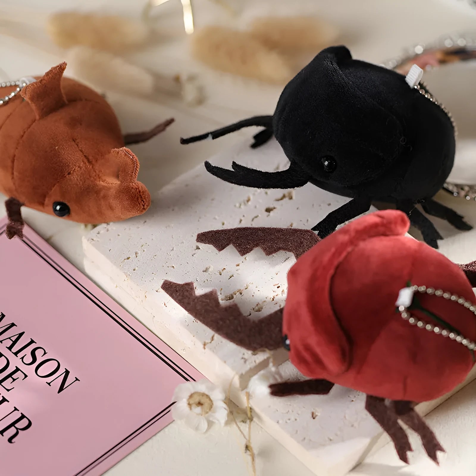 Small black Japanese rhinoceros beetle plush doll pendant keychain with red horn, 10cm tall.