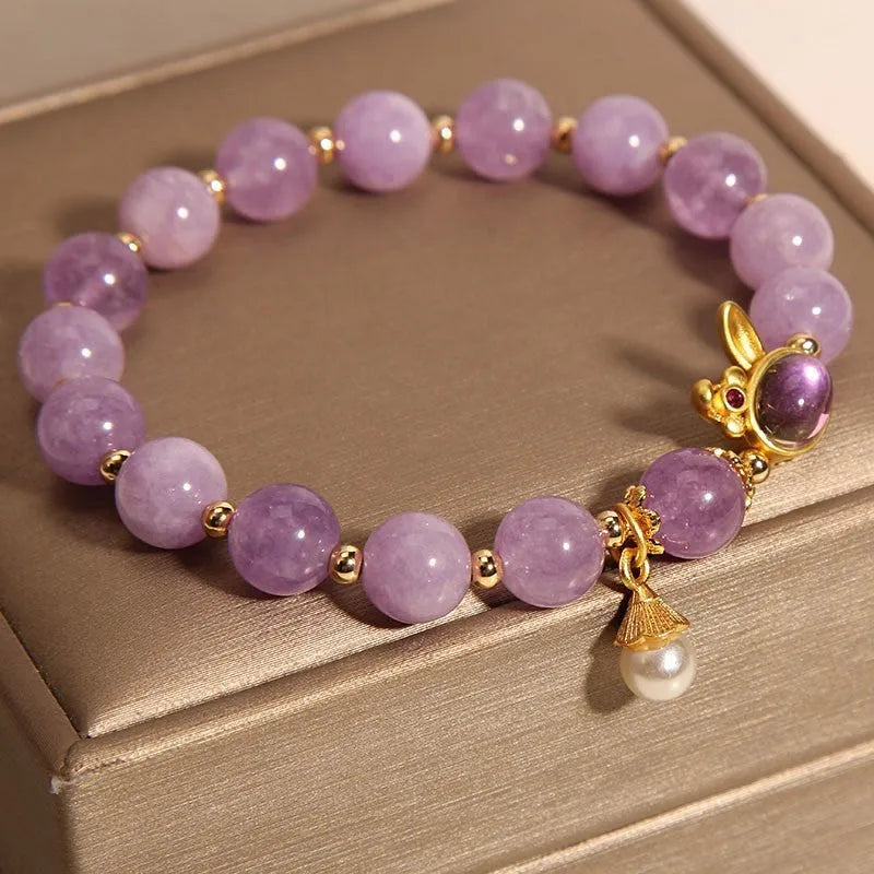 Mauve jade rabbit bracelet with a purplish red jade hare head charm on a crystal band.