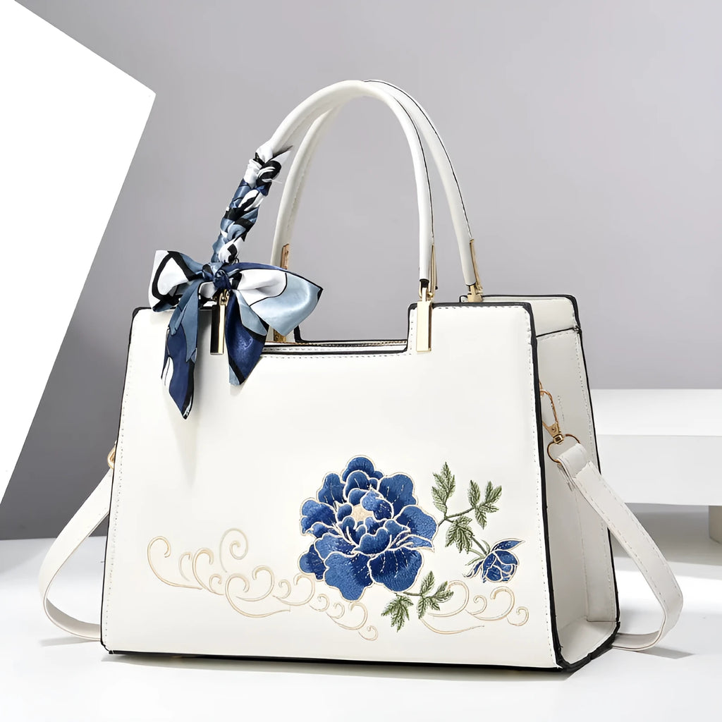 Large capacity embroidered women bag in PU, horizontal square shape, with zipper compartments and contrast colour detailing.