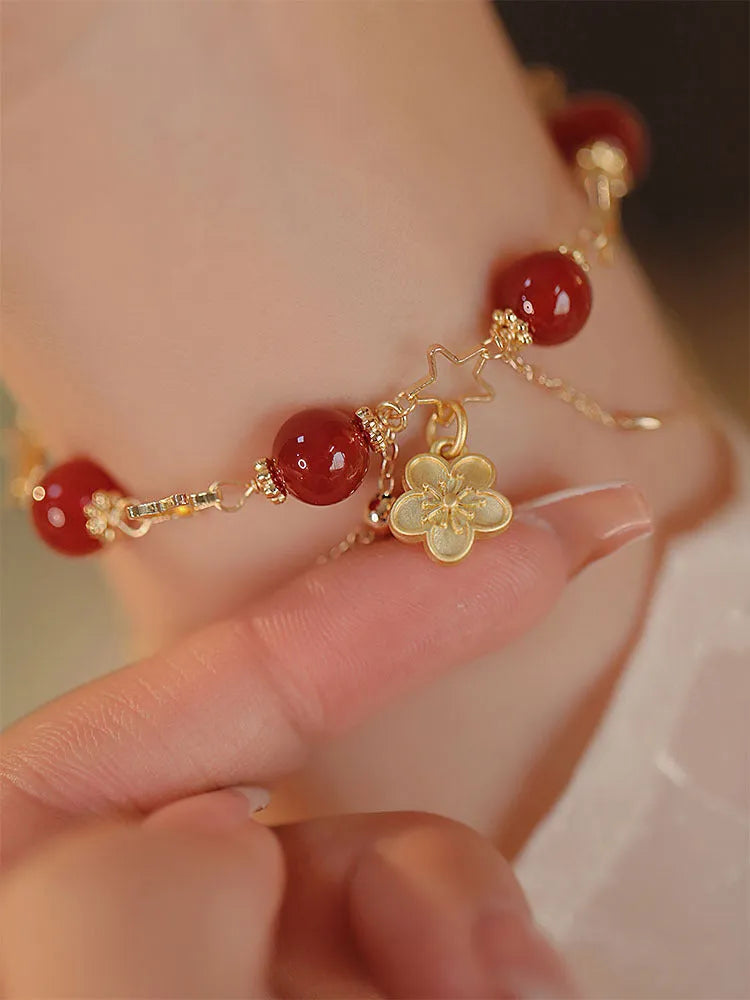 Red agate double layer bracelet with peach blossom floral details on woman's wrist
