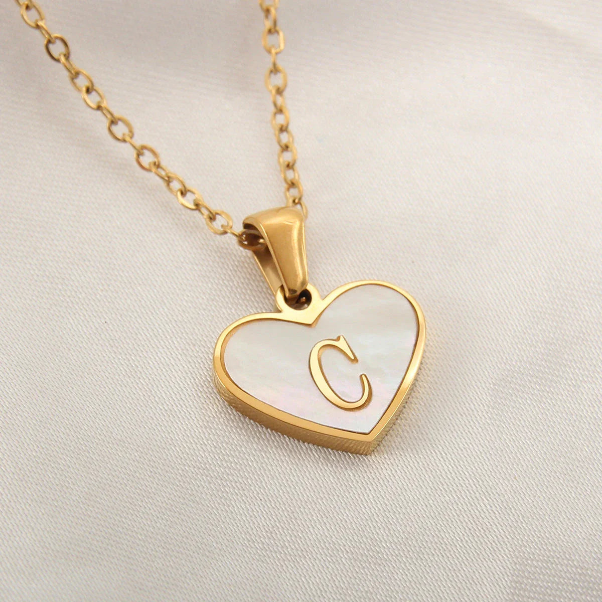 A personalized heart-shaped necklace with a 26-letter charm, crafted from high-quality stainless steel and gold plating.