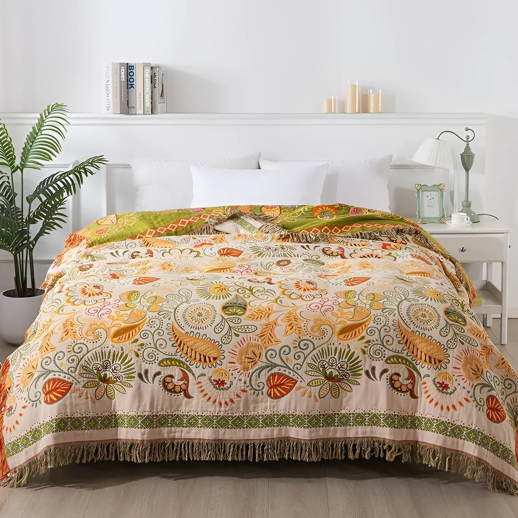 Cotton gauze towel quilt with tassels in beige flower pattern on a bed