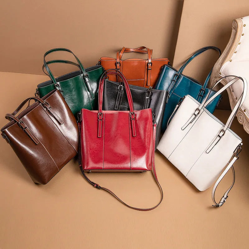 Brown genuine leather retro women's shoulder tote bag with three straps on a table.