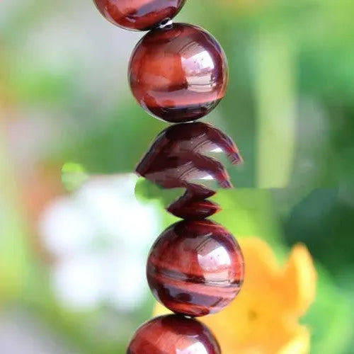 Wooden Tigereye bracelet with Lightning Cat's Eye design on wrist, showing geometric round beads.