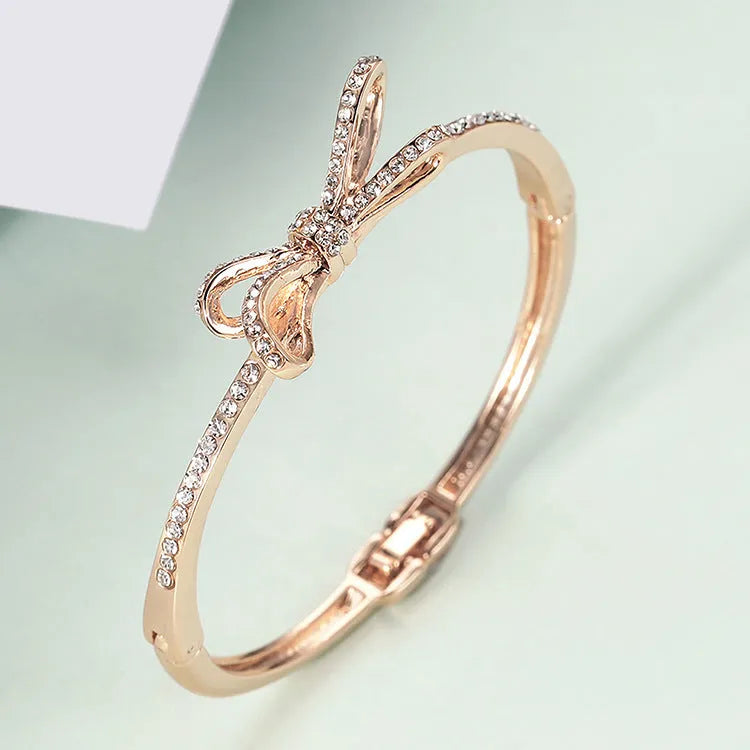 Women's rose gold bow bracelet made from electroplated copper with a diamond feature