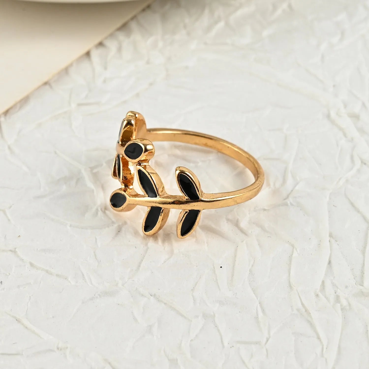 Gold geometric leaf and floral acrylic ring for women on a white background.