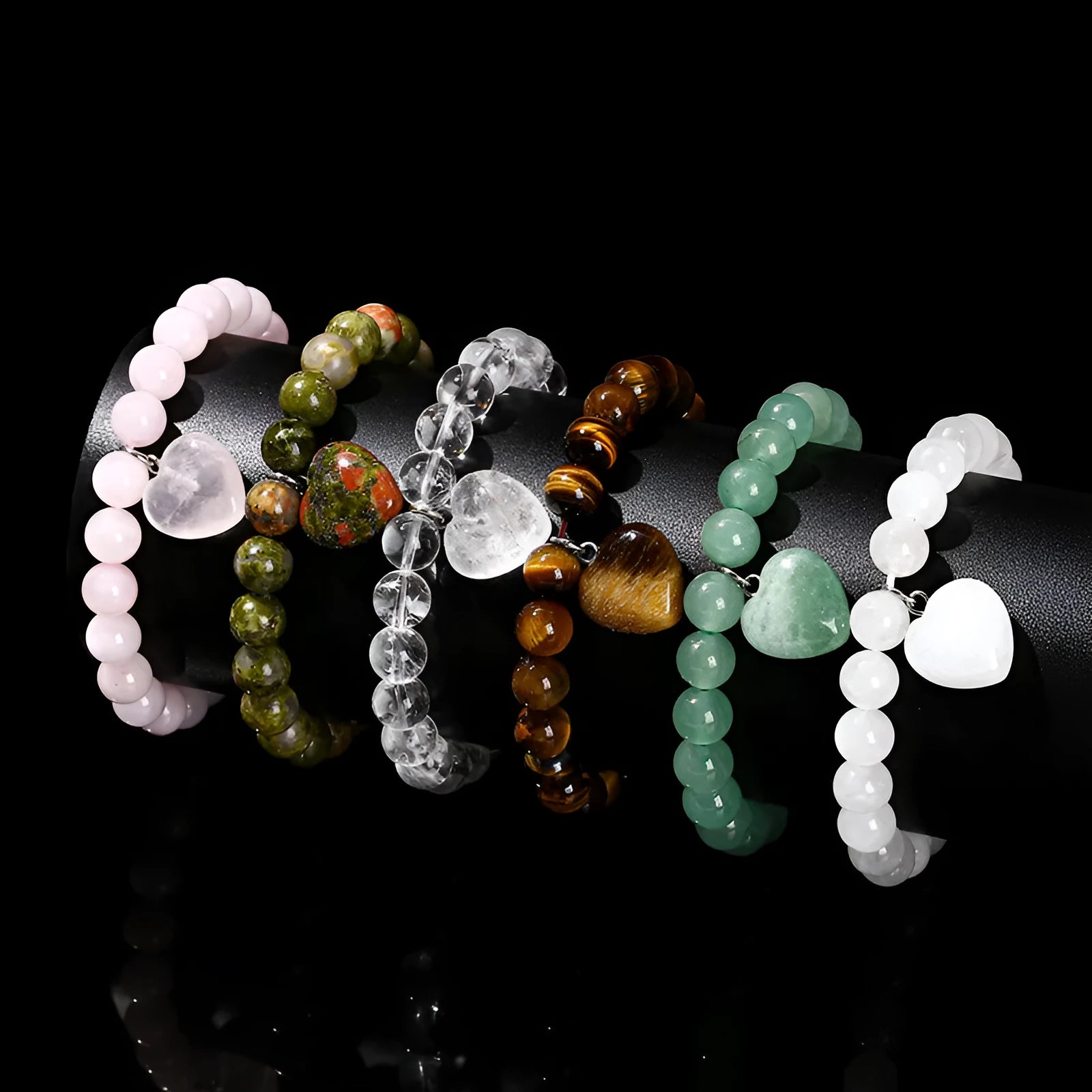Natural stone love heart pendant bracelet on wrist, showing Tigereye, crystal or aventurine beads.