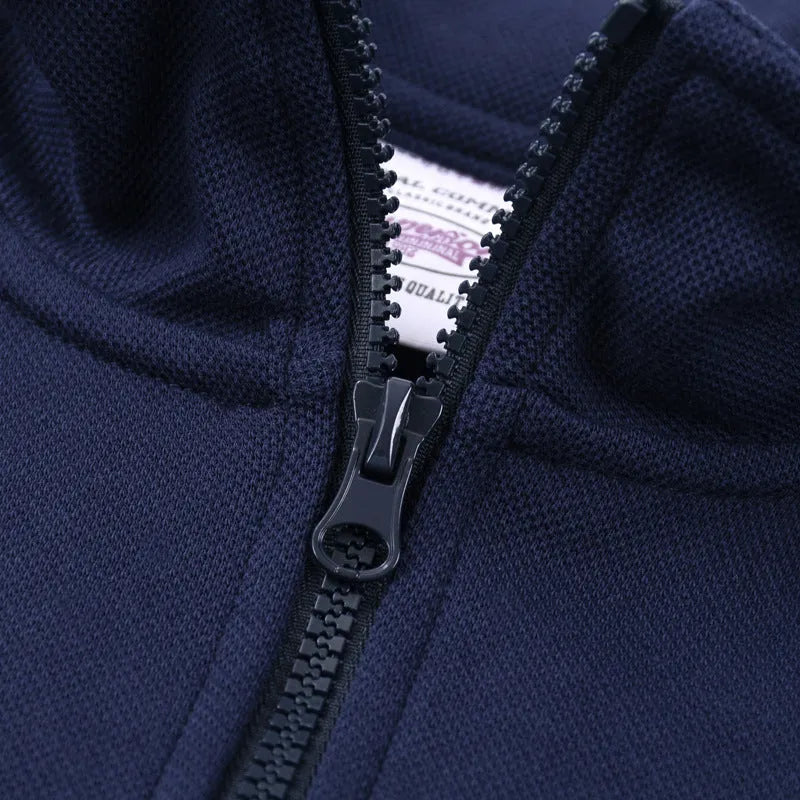 Man wearing a grey zip-front stand collar cotton sports sweater with a straight cut for casual wear.