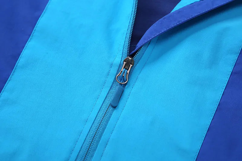 Blue children's long sleeve jacket with front zipper, shown on a hanger.