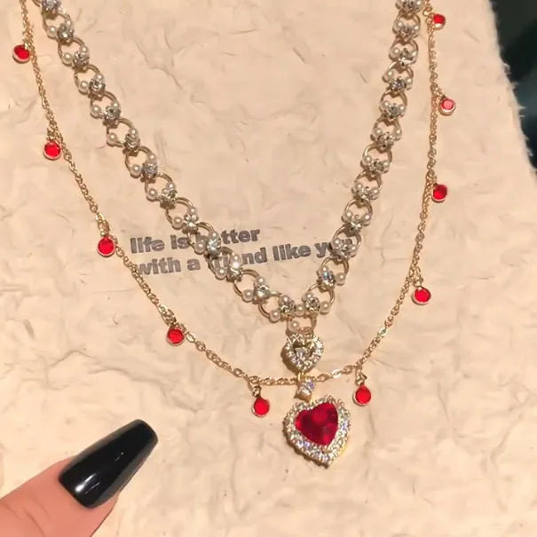 Red double layer necklace with twin chains, a pearl pendant, and a love heart pendant on an adjustable alloy chain.