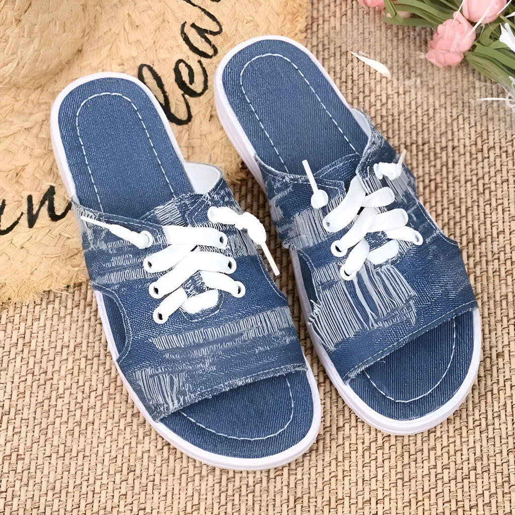 Blue women's flat canvas slippers with a cloth upper and rubber sole.